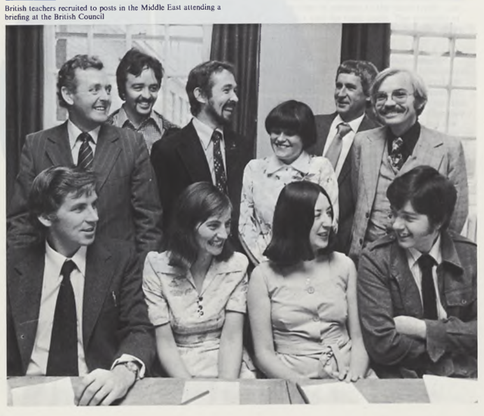 A group of smartly dressed adults chatting and smiling.