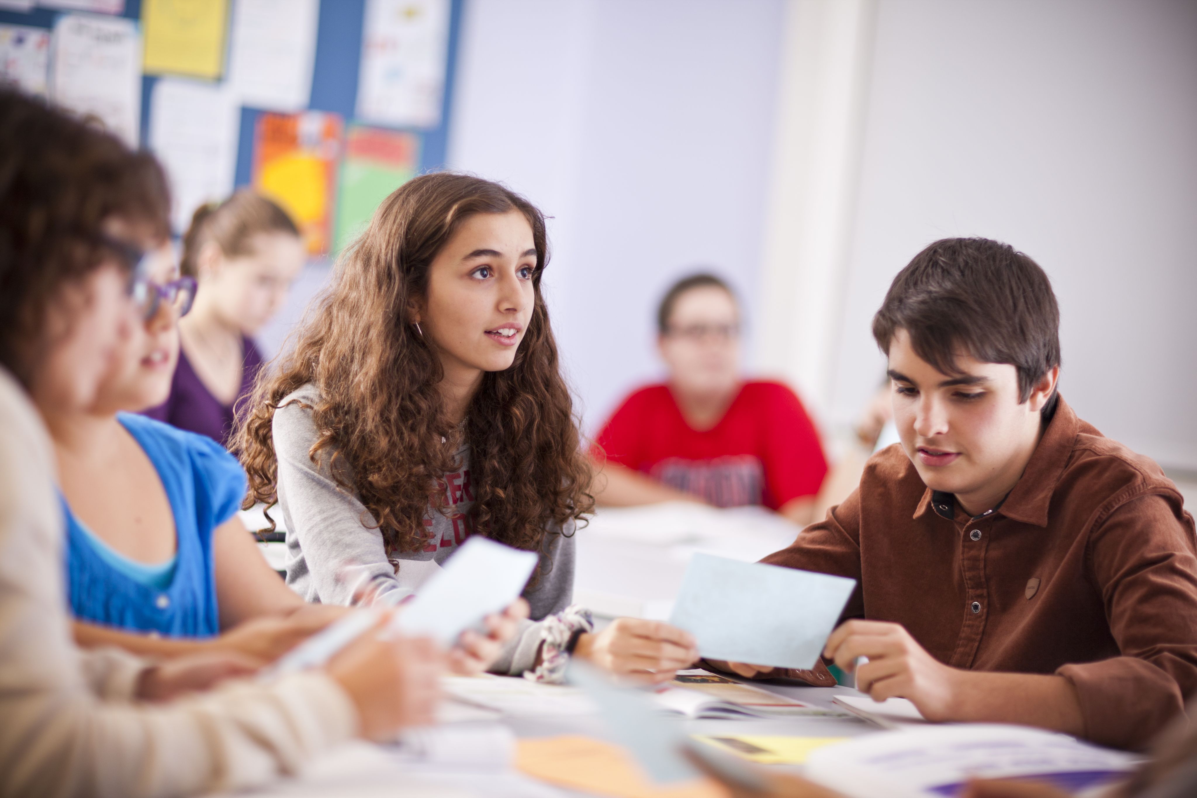 A group of teenagers in a classroom. 