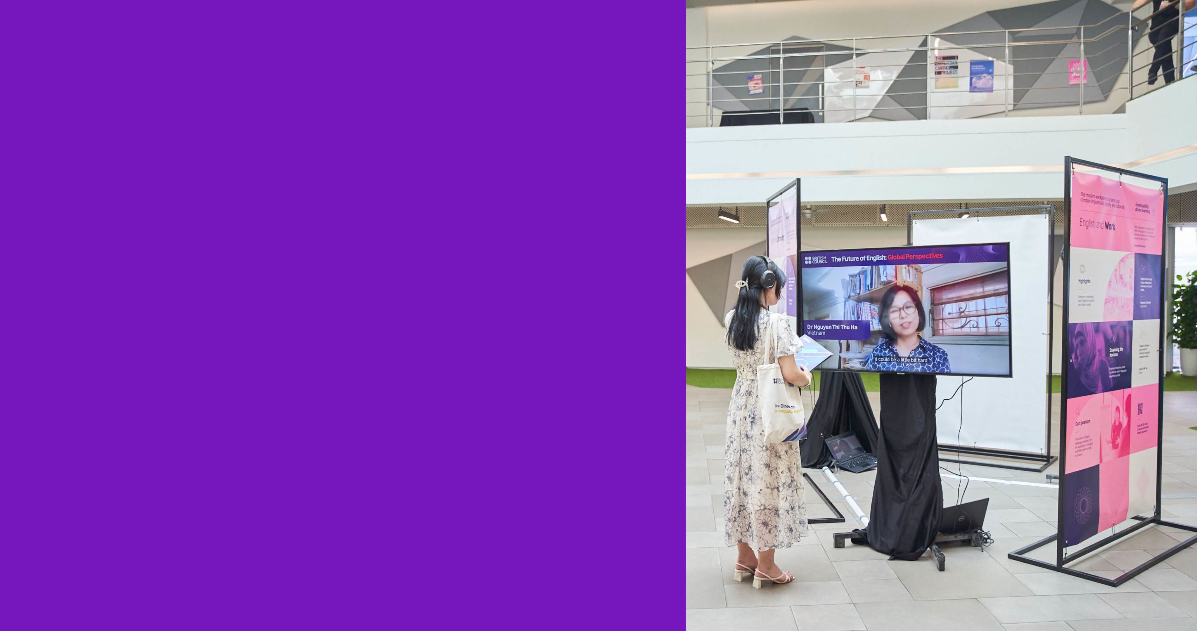 A woman watching the TV at the Future of English exhibition.