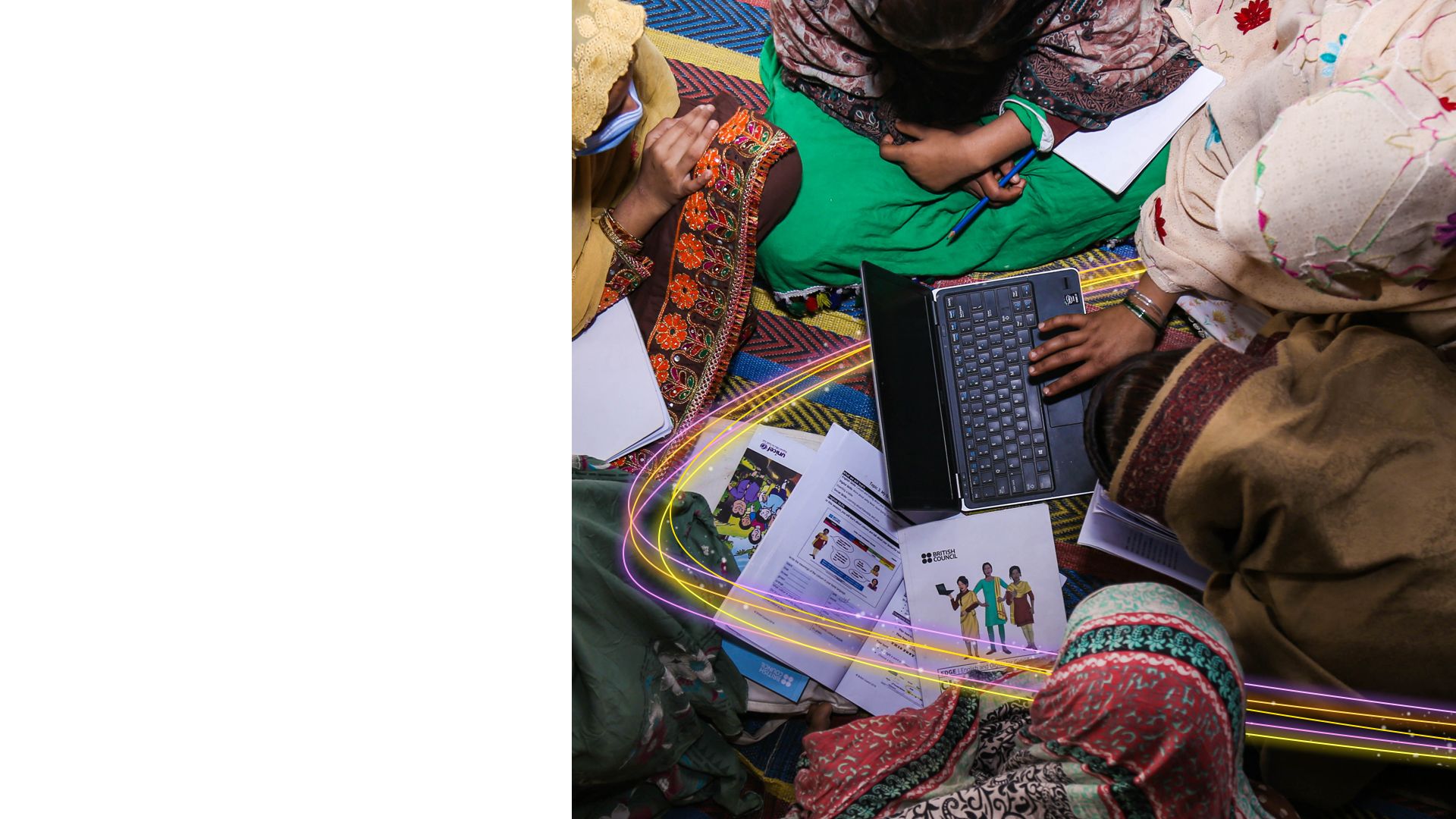 EDGE club members using a laptop with their workbooks open around them.